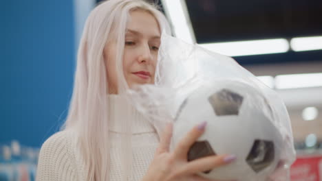 stylish woman with milk colored hair throws ball in well lit toy store, checking bounce and texture against blurred aisles of colorful play items, ambient lighting highlighting movement interaction