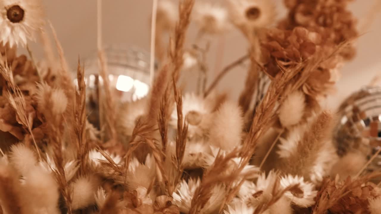 A dried flower wedding arrangement with glitter balls