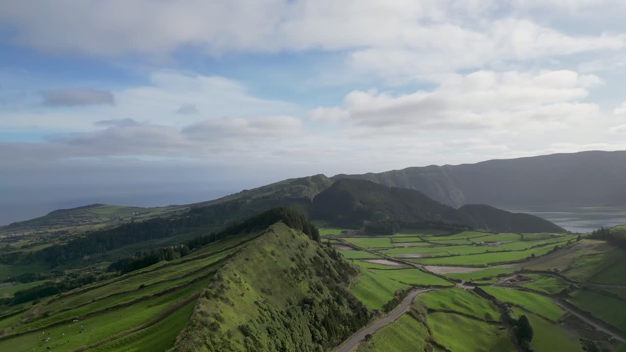 Pemandangan panorama udara sebuah teluk yang dikelilingi kehijauan dengan petak-petak tanah.