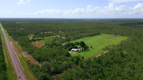 Aerial-drone-of-Rural-Outback-House-on-Empty-Cleared-Lot-as-Vehicle-Drive-Past,-Retreating-Pull-Away