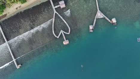 Drone aerial view of indonesian coastline padang west sumatra tropical ocean rainforest jungle trees small fishing village jetty