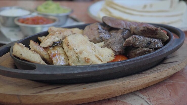 Fajitas Sfrigolanti di Pollo e Manzo con Tortillas e Salse.