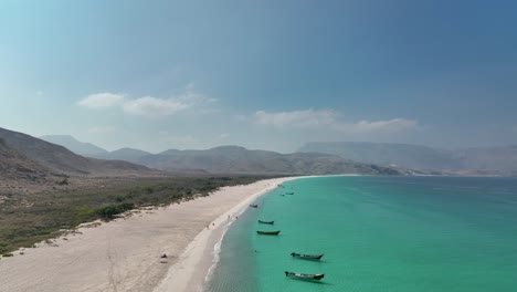 asombrosa vista de arena blanca y agua azul de la playa de shoab con montañas en el fondo en la isla de socotra en yemen