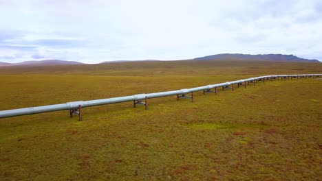 aerial view of the trans-alaska pipeline system, oil transportation pipe at the dalton highway, in arctic, foliage tundra, on a overcast day, in alaska, usa - tracking, drone shot