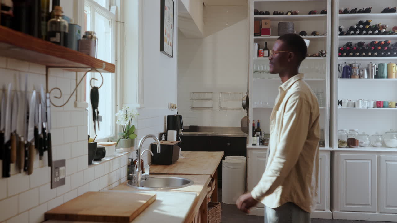 Man in kitchen looking out window