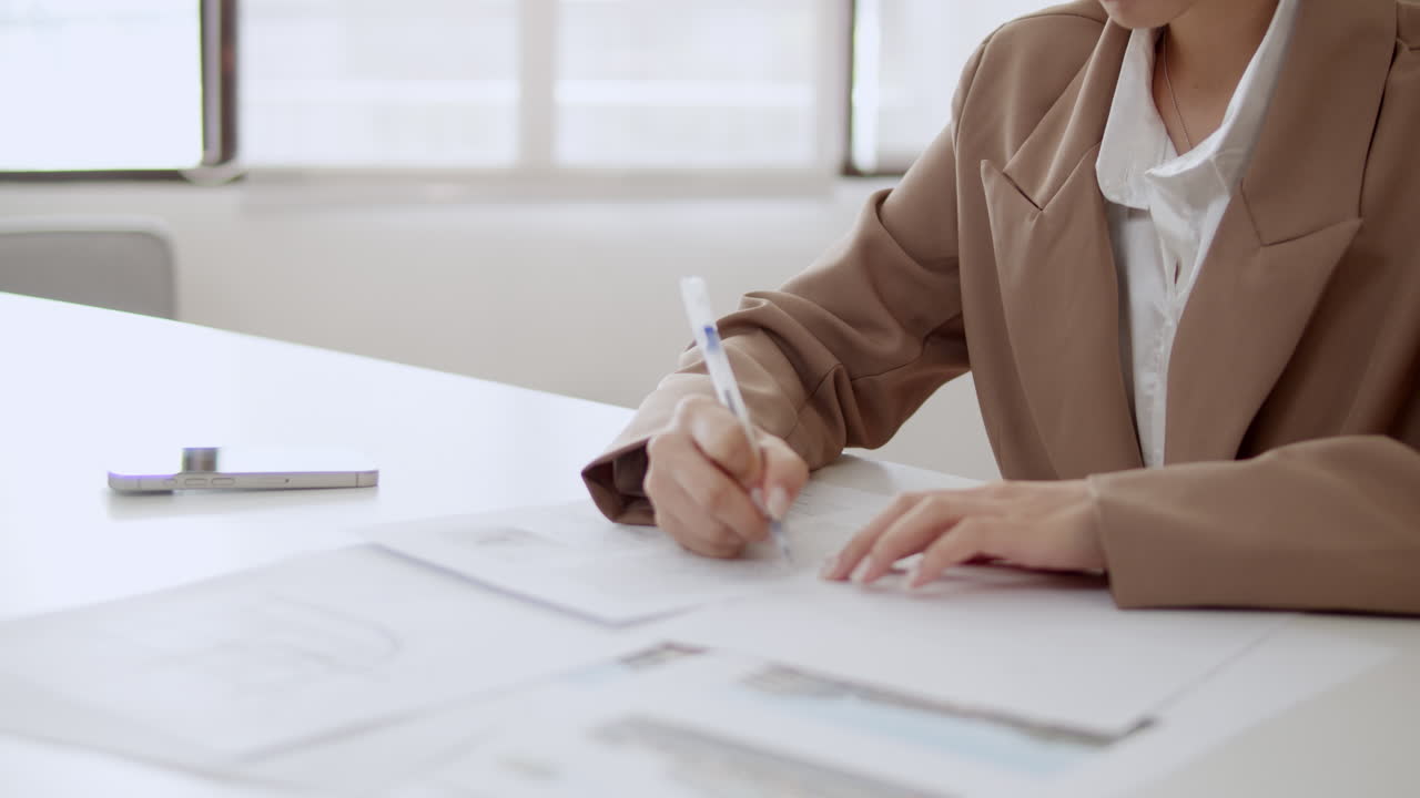 A focused professional diligently signs important documents in a sleek office showcasing commitment and organization.