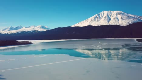 vídeo de drone 4k de montanhas cobertas de neve à beira do lago no alasca durante o inverno