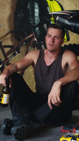man drinking beer in a garage