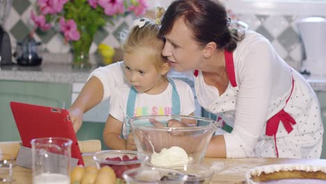 Mother-and-her-cute-young-daughter-in-the-kitchen