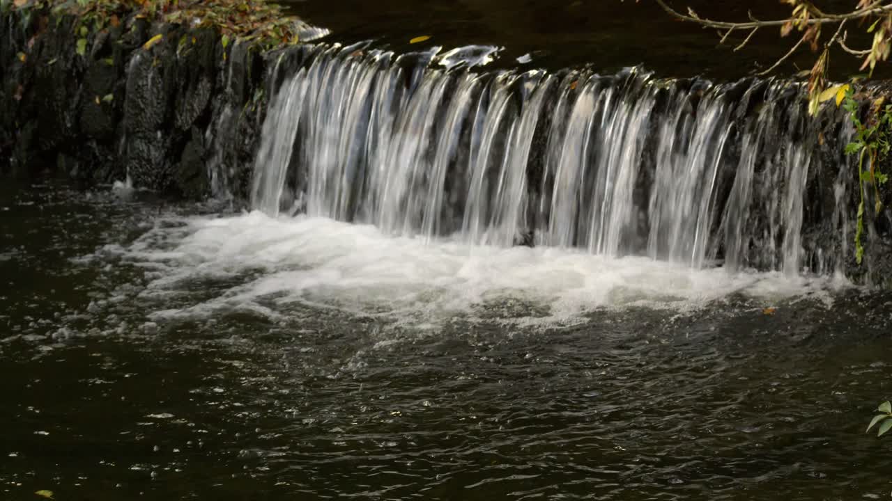 agua que fluye por una cascada hacia una piscina