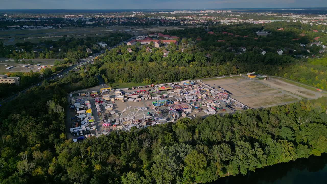 Berlin funfair showing a Ferris wheel, amusement rides, and various stalls from an aerial perspective. Gorgeous aerial view flight panorama overview drone