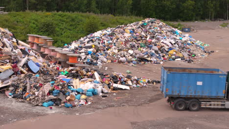 un camión se aleja después de arrojar su carga en la pila de basura para la incineración