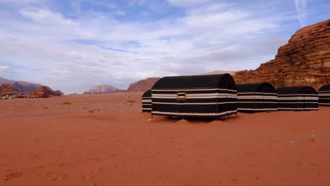 bedouin tents nestled against rugged mountains in the popular tourism destination of wadi rum desert in jordan, middle east