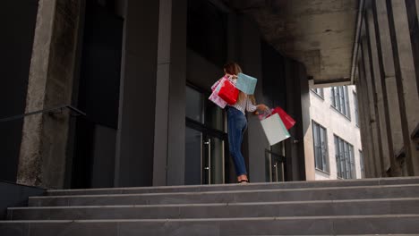 chica con bolsas de compras, girando, bailando, pareciendo satisfecha con la compra, disfrutando de descuentos de precios