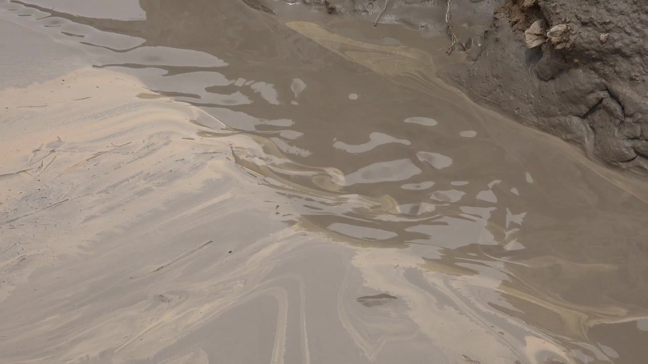 Acqua densa e fangosa che scorre in un ruscello naturale
