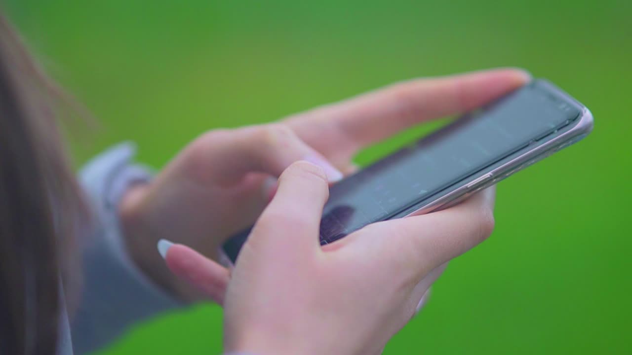niña sosteniendo y escribiendo texto en el teléfono inteligente - mujer usando un teléfono celular con pantalla táctil