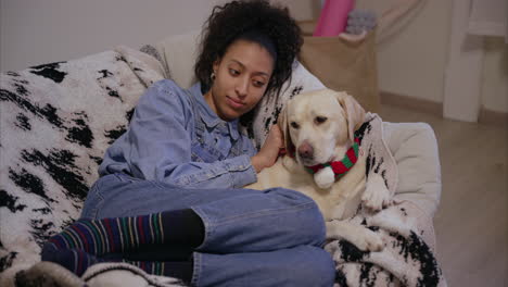 girl smiling and cuddling her yellow labrador retriever on a rocking chair, dog wearing scarf licks her paw, pure love, therapy animal, pet sitting, cozy afternoon at home, emotional support dog