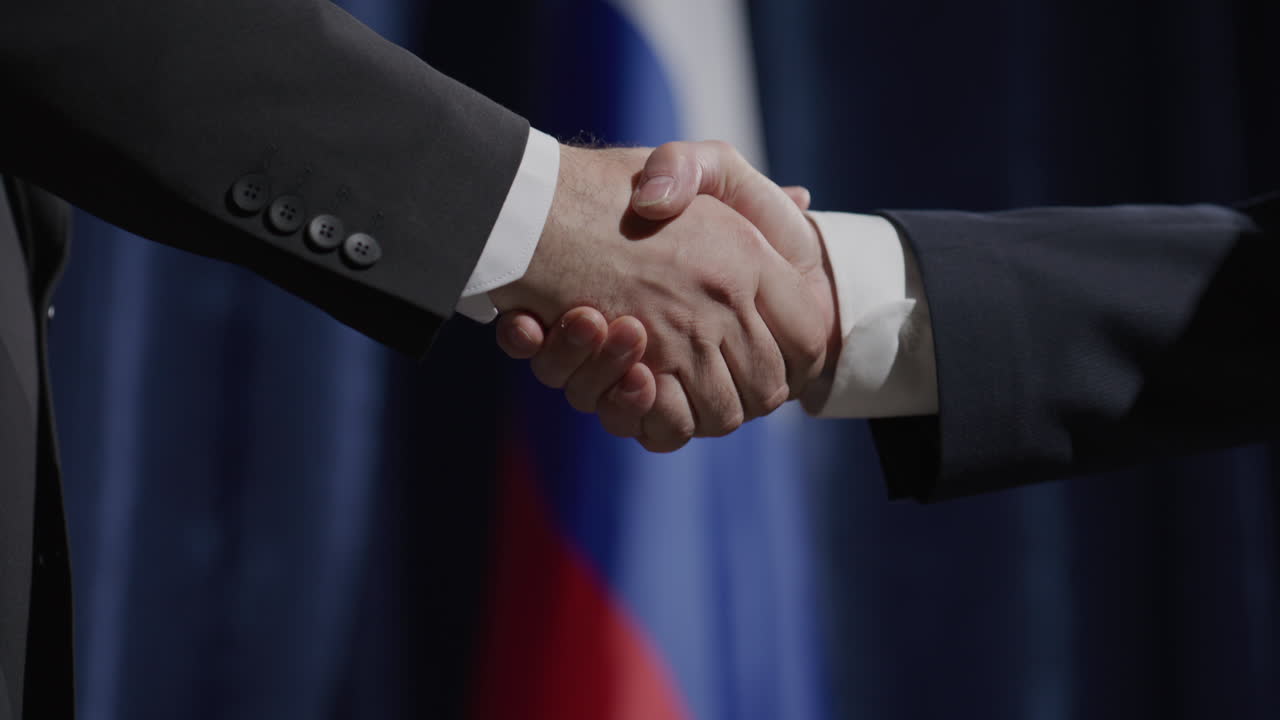 Politicians Shaking Hands in front of Russian Flag at Press Conference
