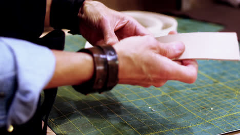 craftswoman making leather belt