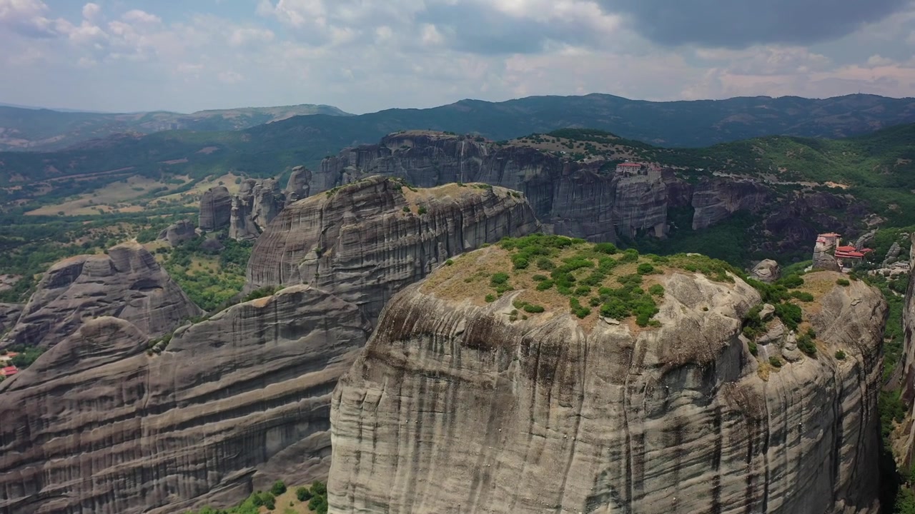 Splendido panorama ripreso da drone dei pilastri rocciosi di Meteora e degli antichi monasteri arroccati sulle scogliere. Il filmato mostra la vasta foresta di pietra, valli lussureggianti e verdi e la città di Kalabaka annidata in basso.
