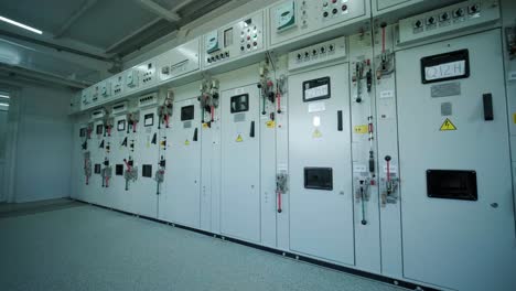 electrical engineer working check the electric current voltage and overload at front of load center cabinet or consumer unit for maintenance in main power distribution system room.