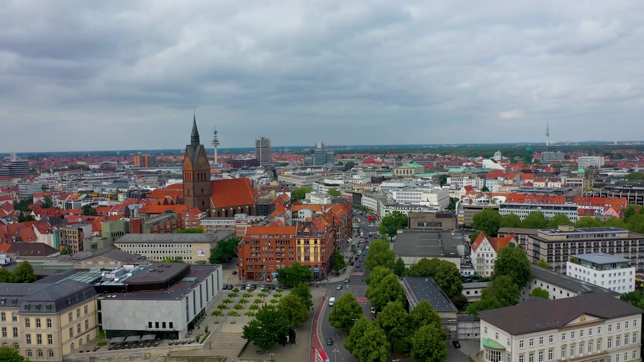 Ripresa aerea cinematografica che rivela il vivace paesaggio urbano di Hannover, Germania, con auto in movimento sulle strade e alberi verdi e rigogliosi