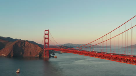 dolly back revealing aerial shot of the golden gate bridge at sunset