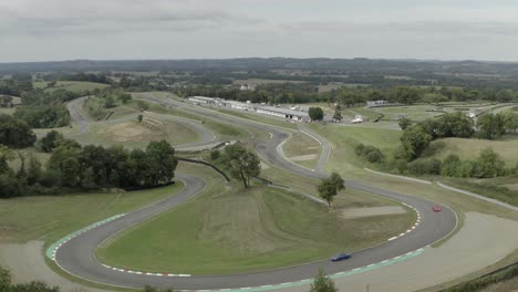 vintage car racing on pau-arnos circuit as seen from drone flying