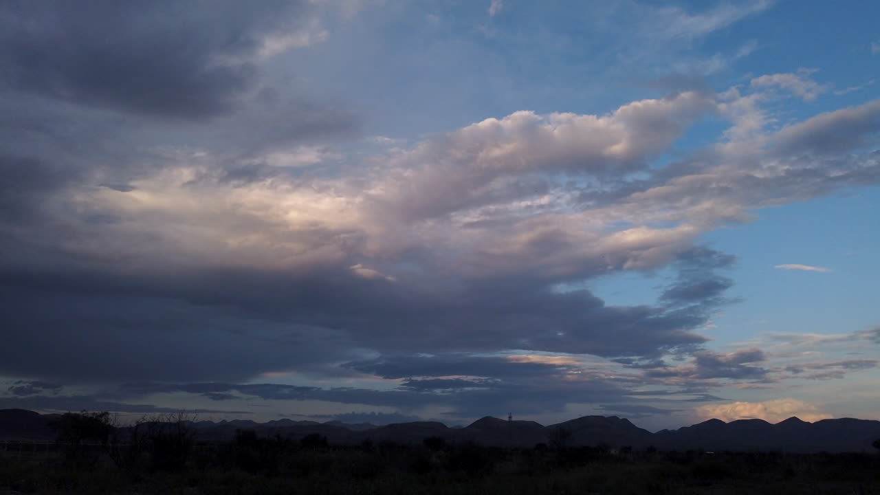 nubes contra un paisaje de montaña desértica al atardecer