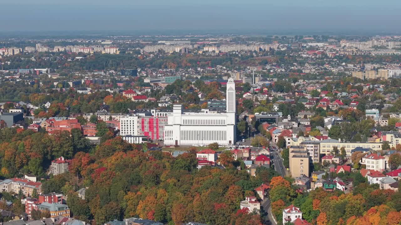 Aerial view of Kaunas, Lithuania in autumn featuring colorful foliage and the iconic Church of the Resurrection dominating the skyline