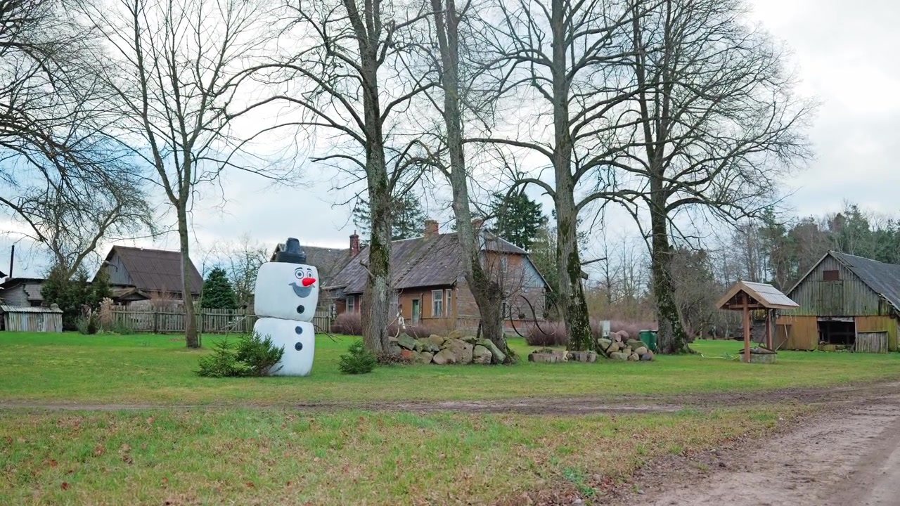 Cour de village paisible avec un bonhomme de neige festif sous des arbres d'hiver dénudés