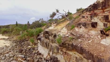 drone aérien montant tiré sur une falaise rocheuse avec des arbres épineux pour révéler mt coolum