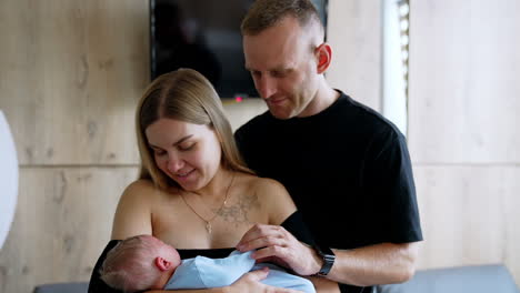 happy new parents with their newborn. lovely caucasian family portrait in a hospital ward.