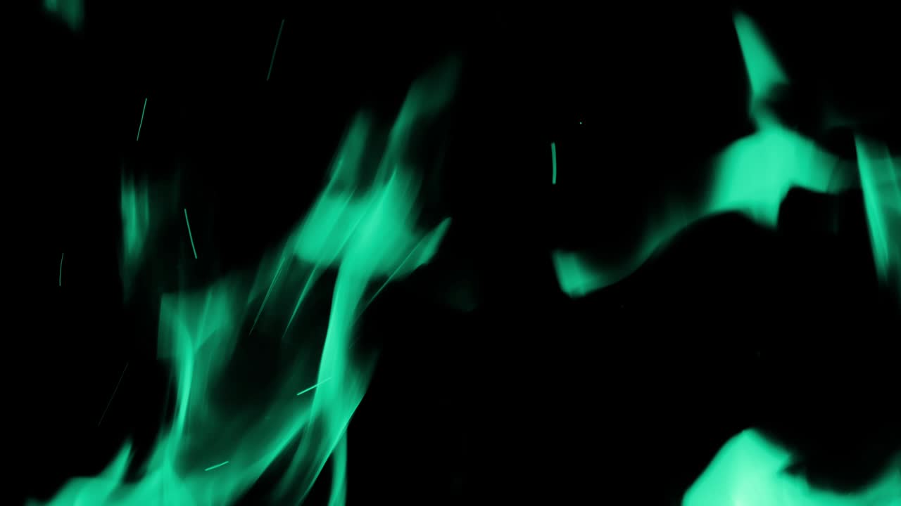 cámara lenta de la línea de fuego o llamas aisladas en fondo negro tonado turquesa.