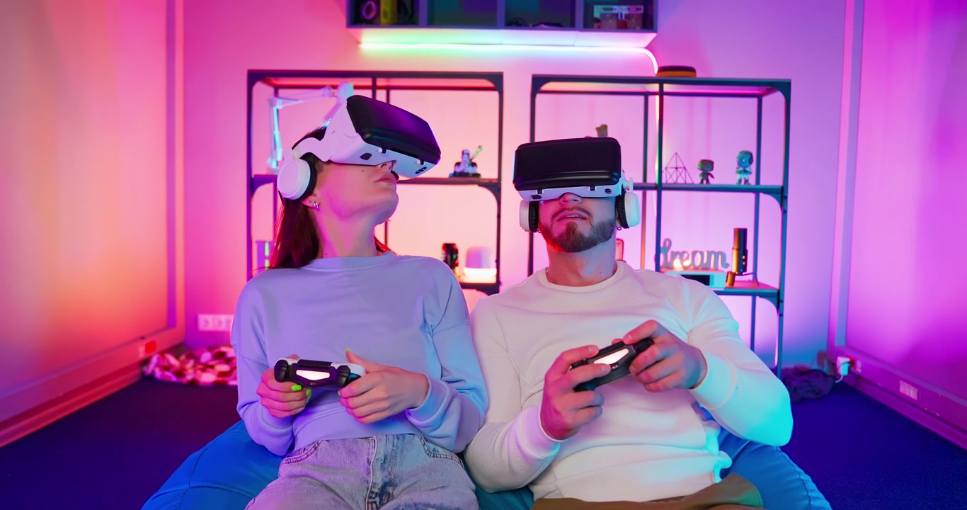Giovane coppia che gioca a videogiochi di realtà virtuale con visori VR