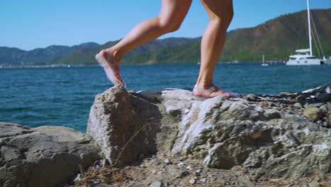 this shot depicts a person joyfully walking by the seaside in turkey, marmaris with a backdrop to some boats and mountains.