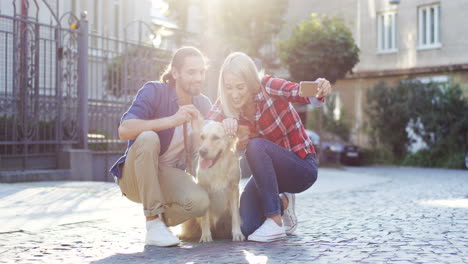 Junges-Paar,-Das-An-Einem-Sonnigen-Tag-Ein-Selfie-Mit-Einem-Labrador-Hund-Mit-Smartphone-Auf-Der-Straße-Macht