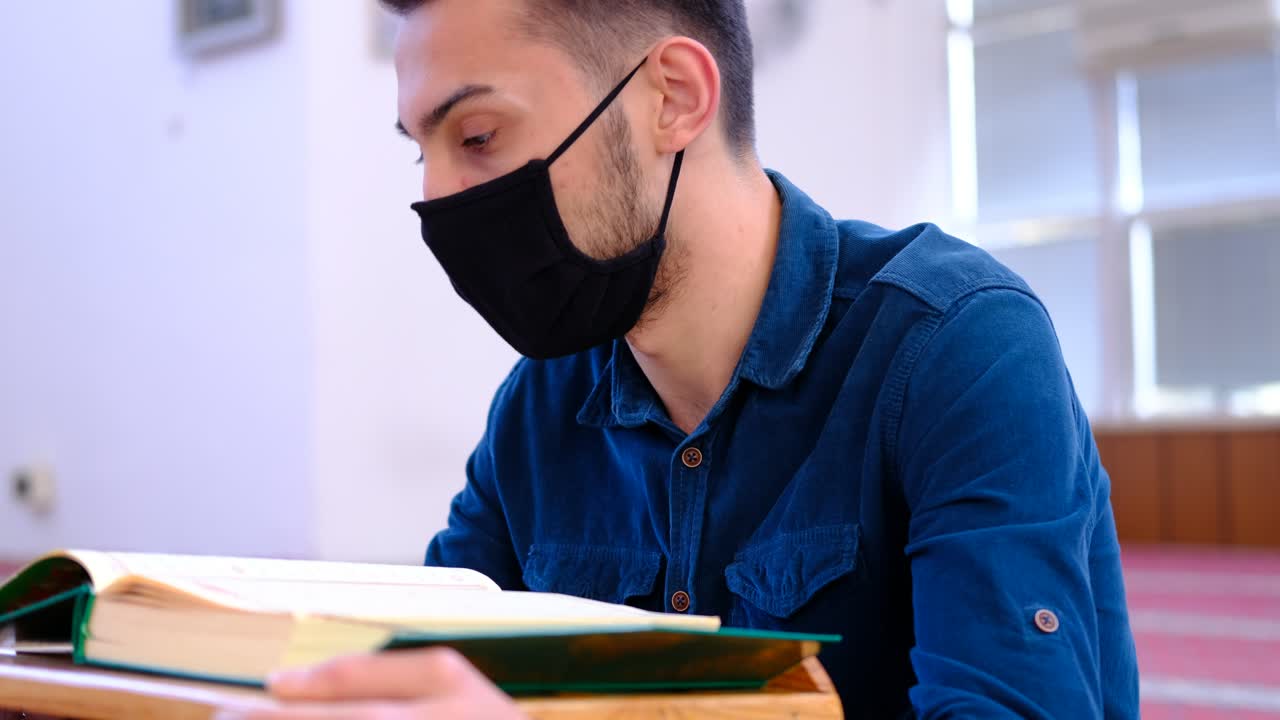 joven musulmán usa una máscara y lee el corán en la mezquita