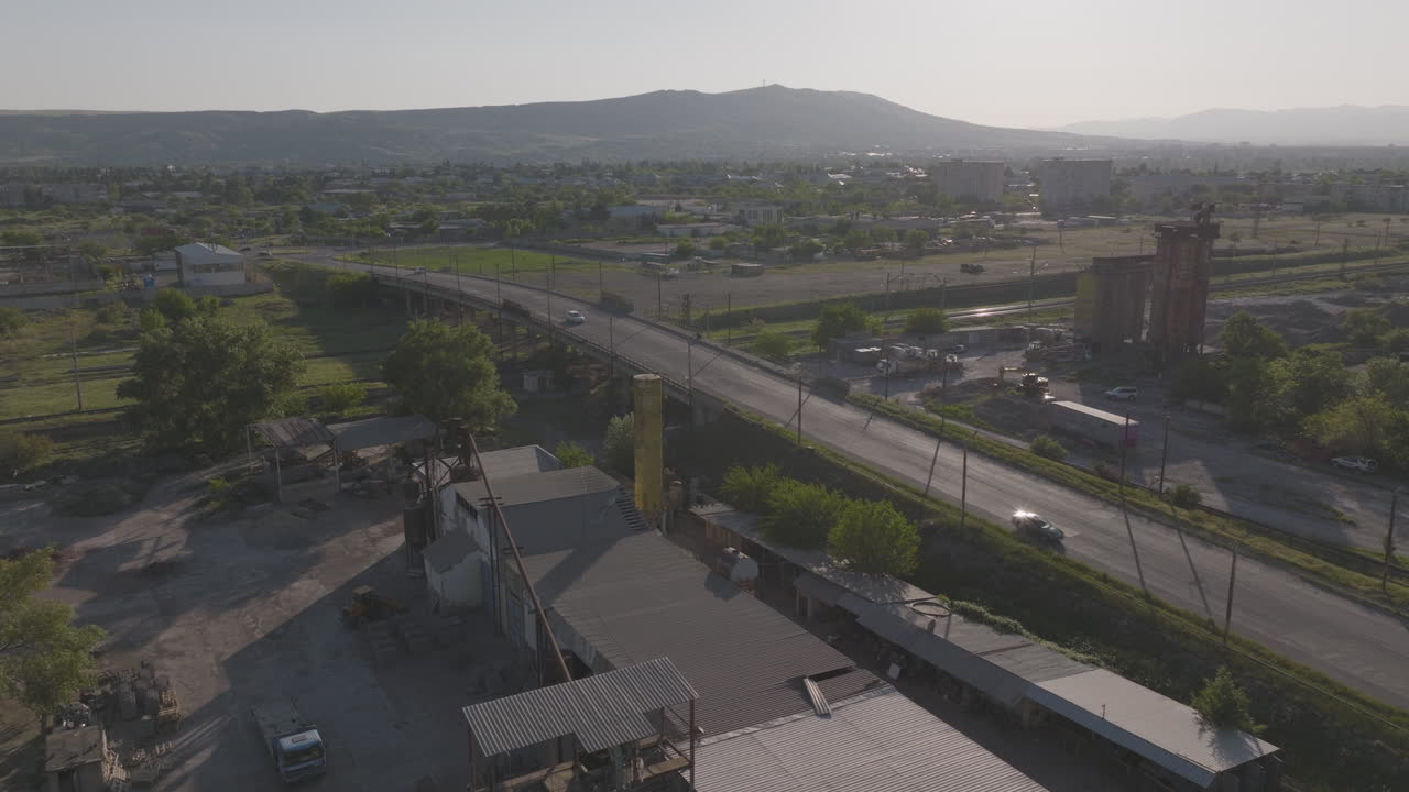 toma aérea de autos y camiones que cruzan un puente ferroviario