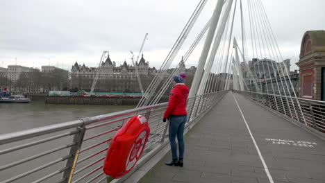 slow motion shot of young woman and the view she has from the golden jubilee bridge, london