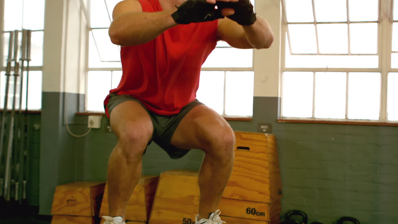 hombre en forma haciendo saltos de caja en el gimnasio