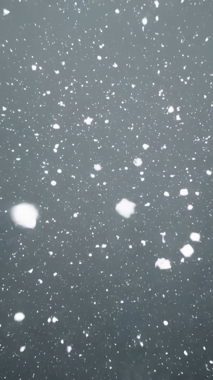 Primer plano de copos de nieve blancos cayendo sobre un fondo oscuro