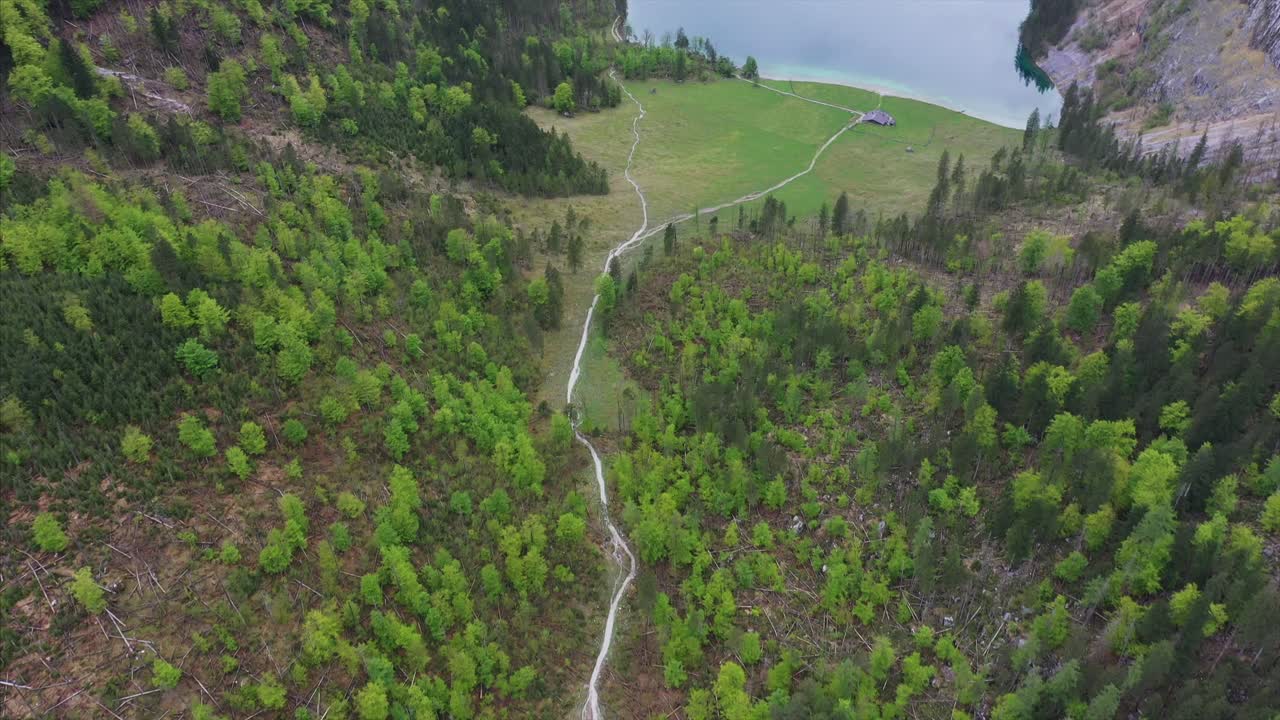 vista aérea del valle de montaña con lago y sendero de senderismo