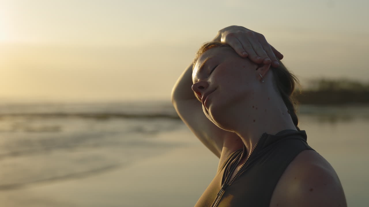 Mujer practicando yoga en la playa al atardecer