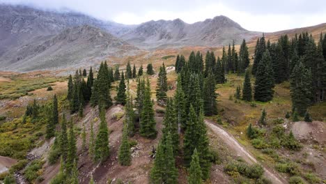 4k aerial drone footage of trees and forest at mayflower gulch with mist on mountains near leadville and copper mountain colorado summit county