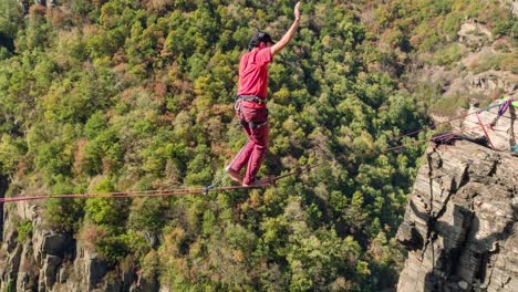 man slacklining across a mountain cliff