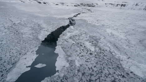 POV-footage-of-a-winter-boat-journey-through-Norway's-Geirangerfjord,-capturing-stunning-views-of-ice-in-the-water-from-the-surrounding-snowy-mountains