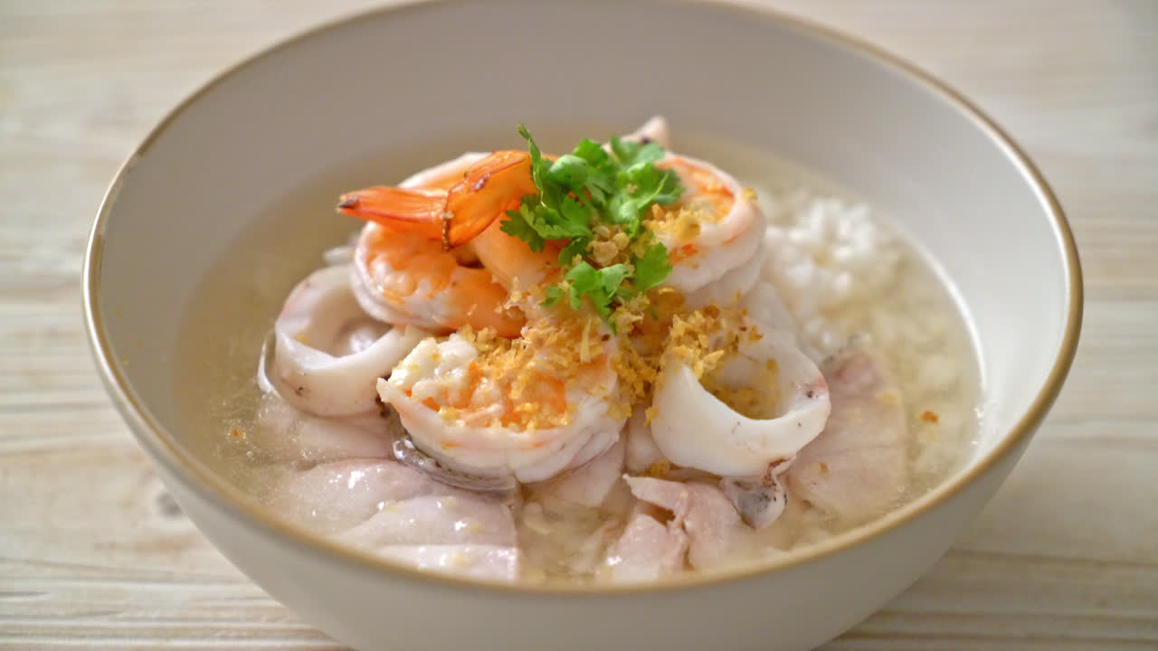 해물(새우, 오징어, 생선)을 곁들인 죽 또는 삶은 쌀국수 그릇