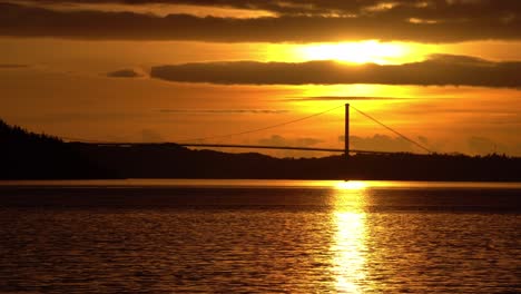 espectacular puesta de sol naranja vibrante sobre el puente askoy visto a través de byfjorden en sandviken bergen noruega