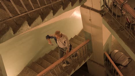 man walking down stairs in an old building